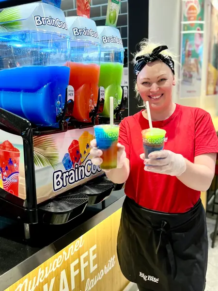 Dame fra Big Bite smiler mot kamera og holder slush