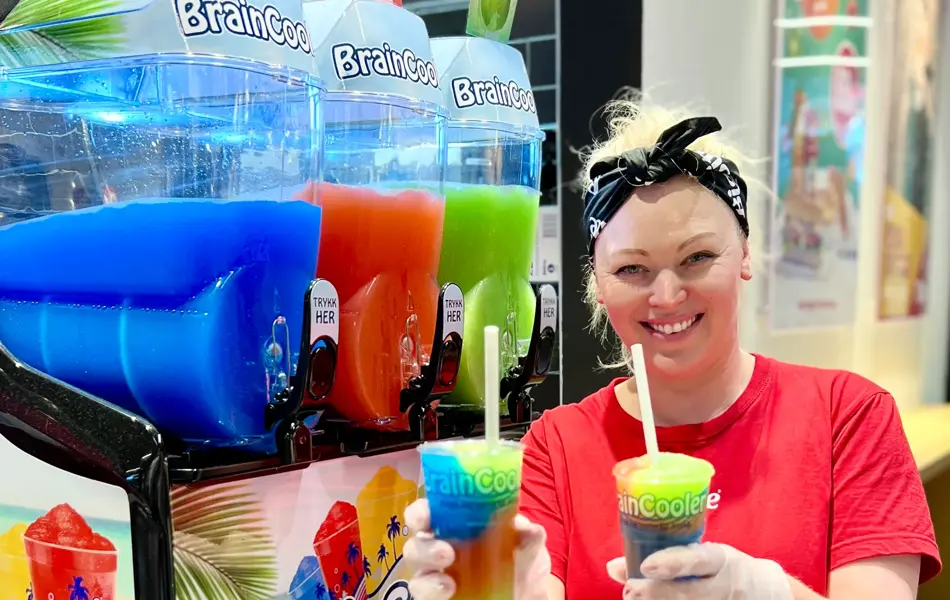 Dame fra Big Bite smiler mot kamera og holder slush