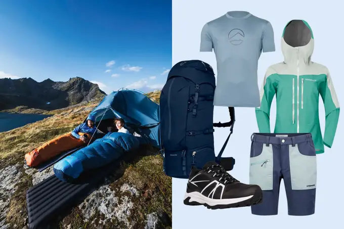 To personer i sovepose på et fjell, tusekk, t-skjorte, vindtett jakke, shorts og tursko.