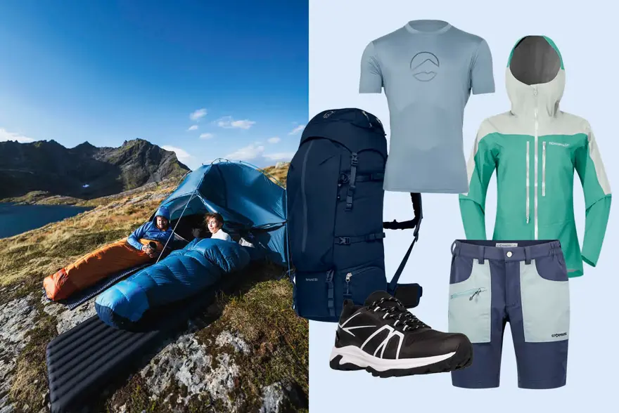 To personer i sovepose på et fjell, tusekk, t-skjorte, vindtett jakke, shorts og tursko.