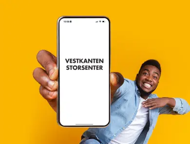 mann som smiler med telefon i hånden