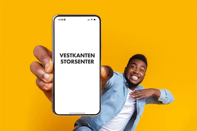 mann som smiler med telefon i hånden