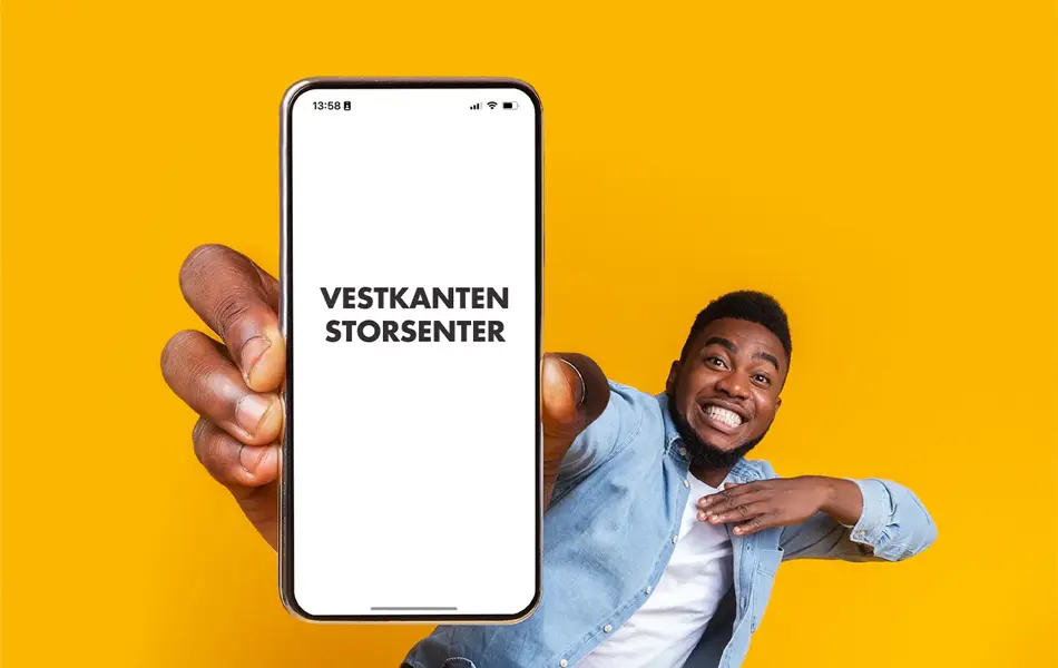 mann som smiler med telefon i hånden