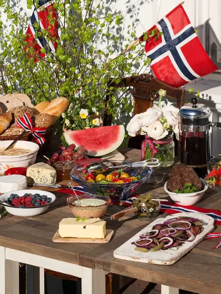 Bord fylt med oster, melon, brød og bær