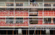 Fasaden av Kjøpmannsgata 15 i Trondheim, retning Nidelva. Fasaden er dekket med stillaser og kledningen er i ferd med å byttes. Skilt med Thon Eiendom, Consto m.fl. henger på.