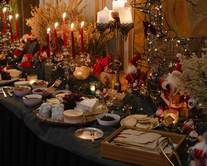 Julebuffet dekket med julepynt, nisser, røde lange lys og julenek