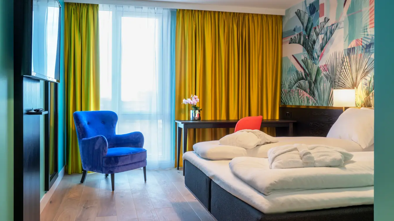 Dobbeltseng god gulvplass, smart tv, lenestol og arbeidspult med friske farger på Thon Hotel Storo i Oslo