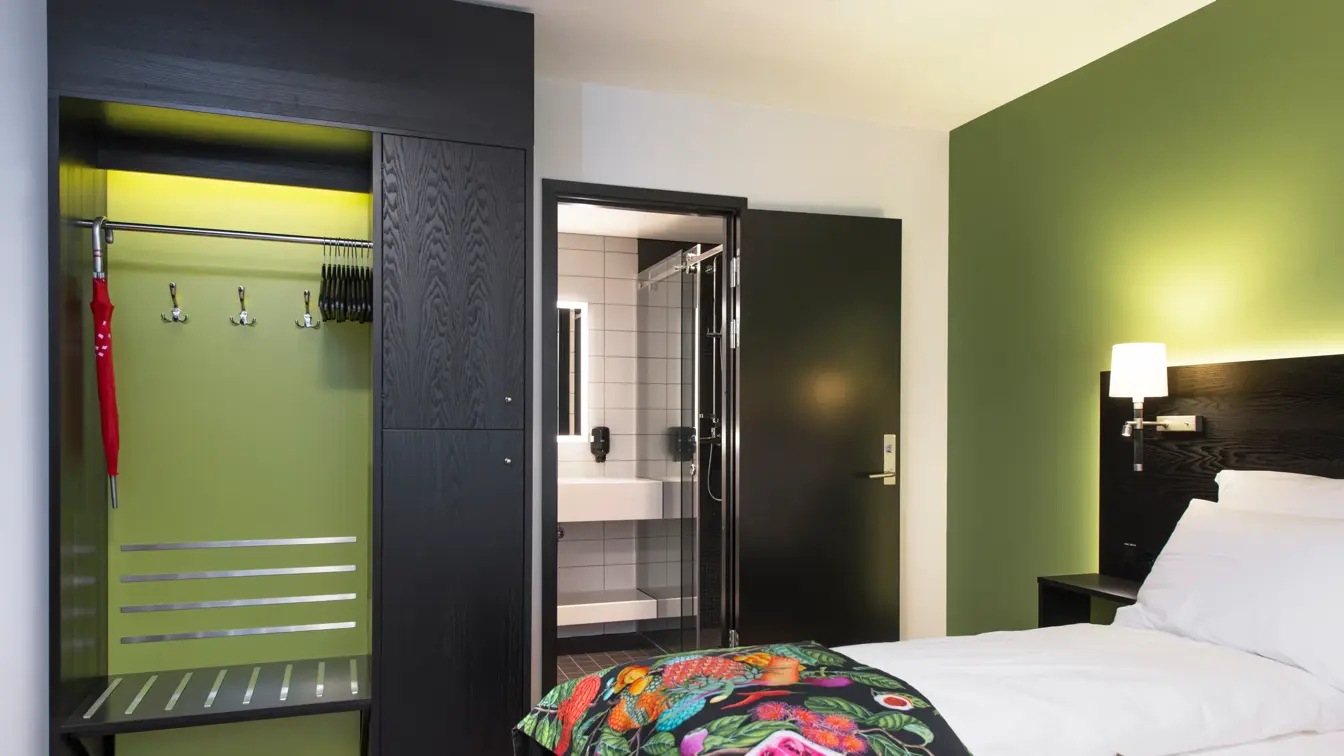 Seng, garderobe og bad i superiorrom på Thon Hotel Vika Atrium i Oslo
