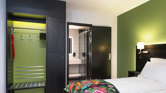 Seng, garderobe og bad i superiorrom på Thon Hotel Vika Atrium i Oslo
