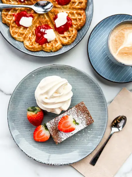 Kake, vafler og kafe på et bord