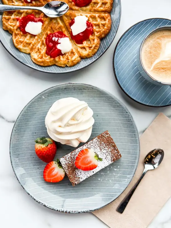 Kake, vafler og kafe på et bord