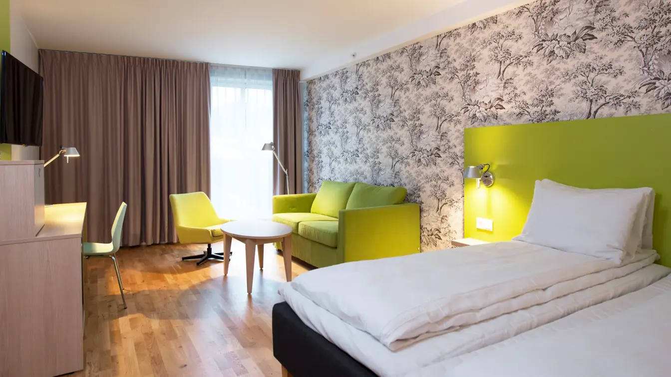 Dobbeltseng og sittegruppe i business room på Thon Hotel Sandven