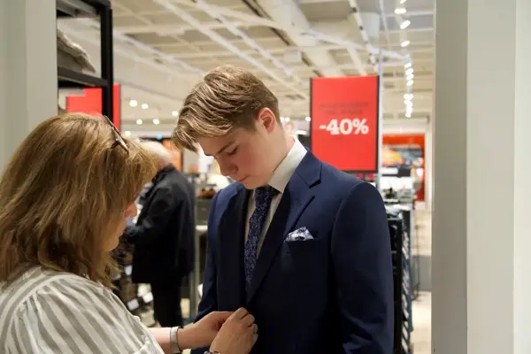 dame hjelper gutt med dress