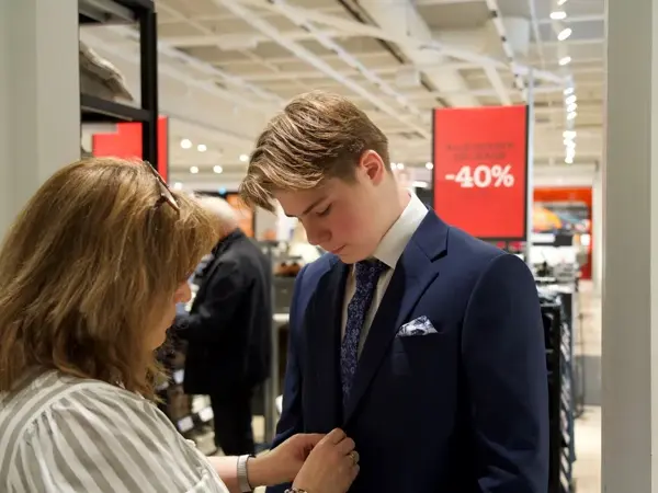dame hjelper gutt med dress