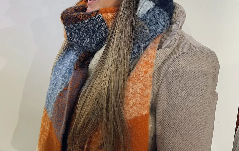 ansatt hos vero moda viser frem lys lue med dusk og fargerikt skjerf