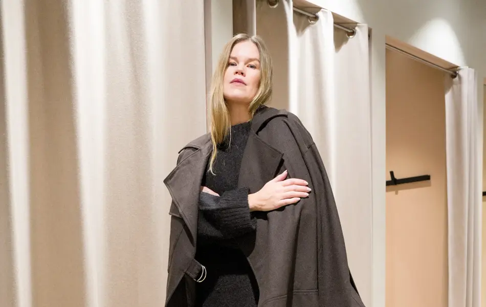 Dame i brun cape over genser ogs kjørt i strikk og brune uggs