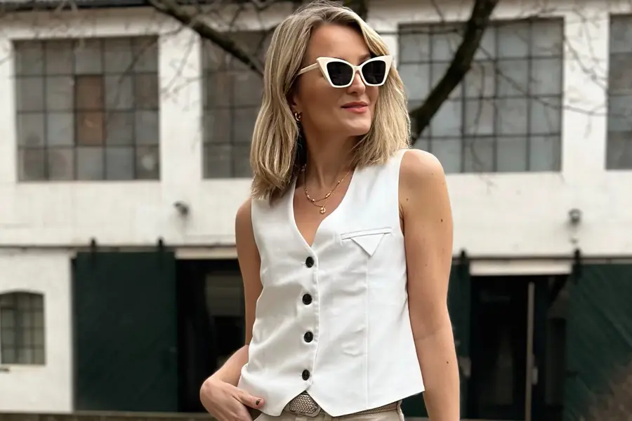 dame som poserer med hvit vest og hvite solbriller