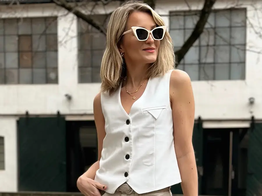 dame som poserer med hvit vest og hvite solbriller