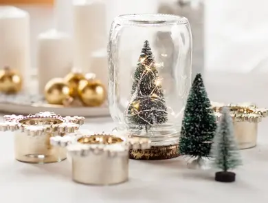 Glass med juletre, stearinlys, julekuler og diverse julepynt