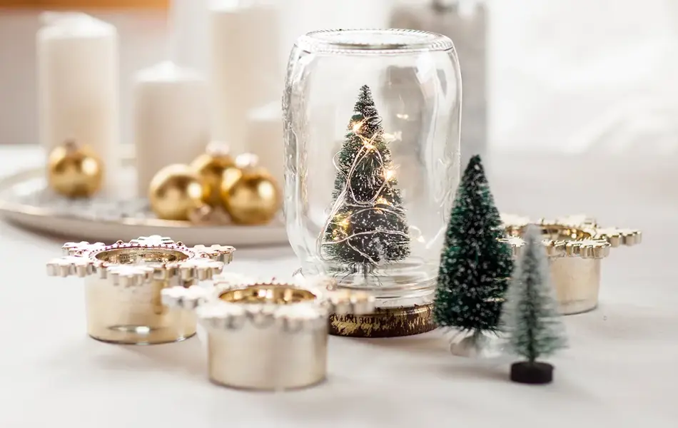 Glass med juletre, stearinlys, julekuler og diverse julepynt