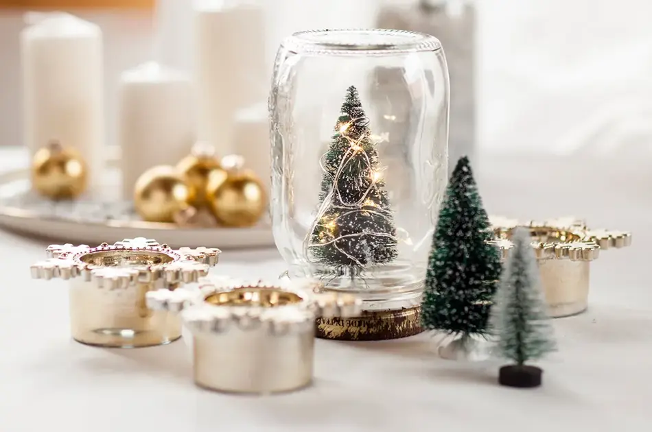 Glass med juletre, stearinlys, julekuler og diverse julepynt