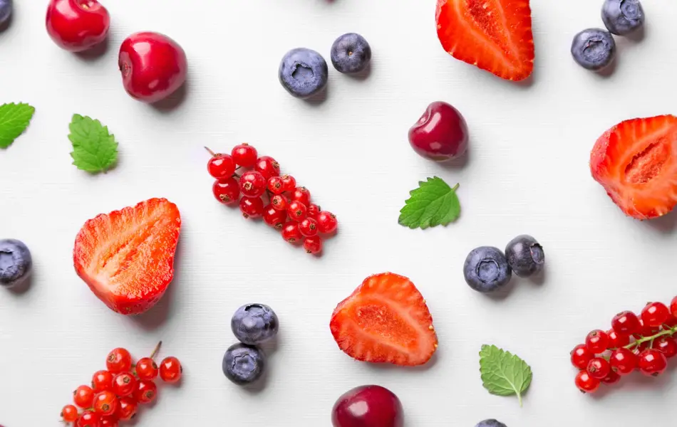 Flat lay av rips, blåbær, kirsebær og jordbær på hvit bakgrunn