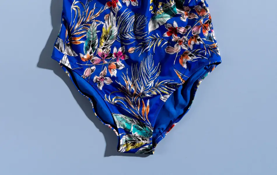 Blå badedrakt med blomster mønster på blå bakgrunn