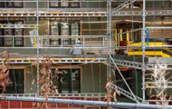 En person som jobber i stillas på fasaden til Kjøpmannsgata 15 i Trondheim, retning vollen. 
