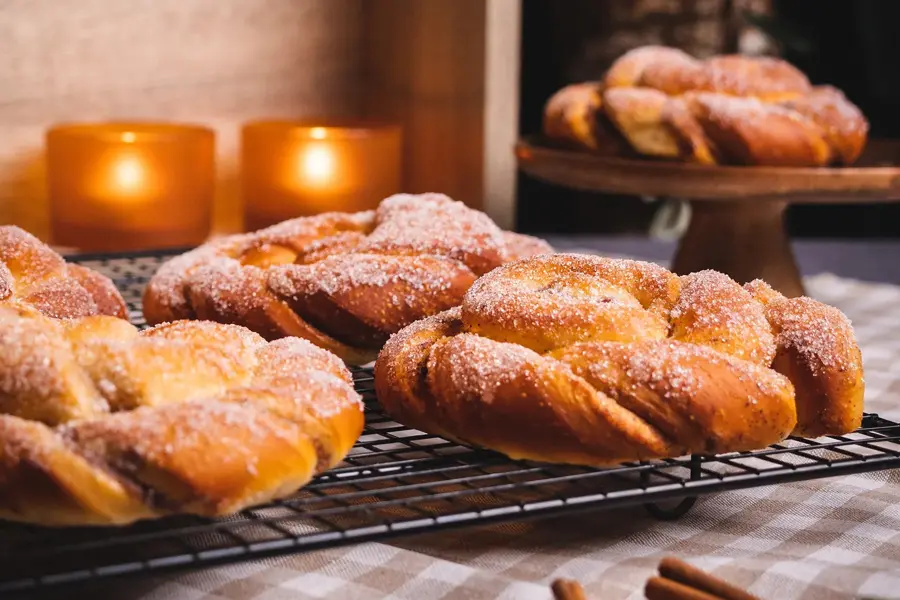 Kanelsnurrer med stearinlys i bakgrunnen