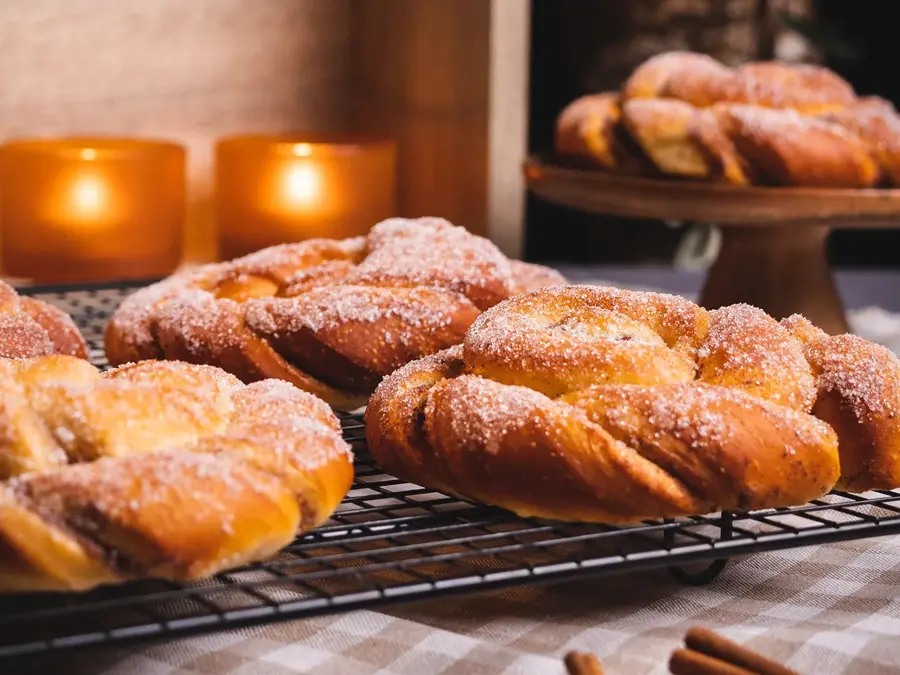 Kanelsnurrer med stearinlys i bakgrunnen