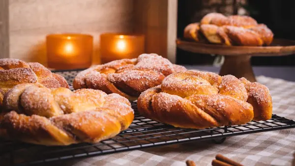Kanelsnurrer med stearinlys i bakgrunnen