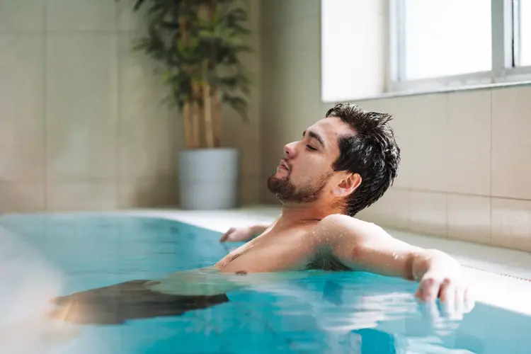 Mann som slapper av i bassenget på Vestkanten Spa