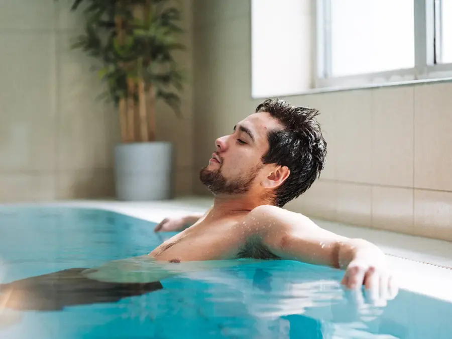 Mann som slapper av i bassenget på Vestkanten Spa