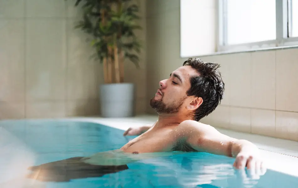 Mann som slapper av i bassenget på Vestkanten Spa