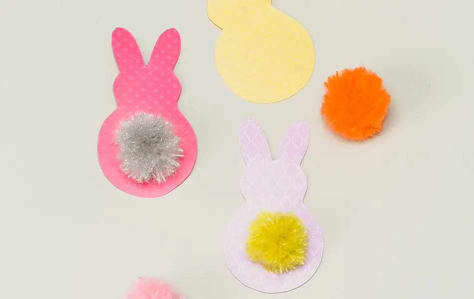 Tre påskeharer klippet i papir med fargerike dusker