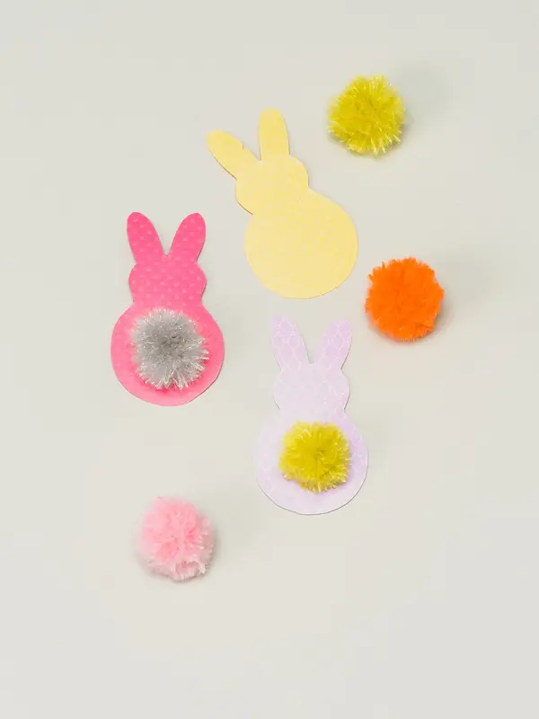 Tre påskeharer klippet i papir med fargerike dusker