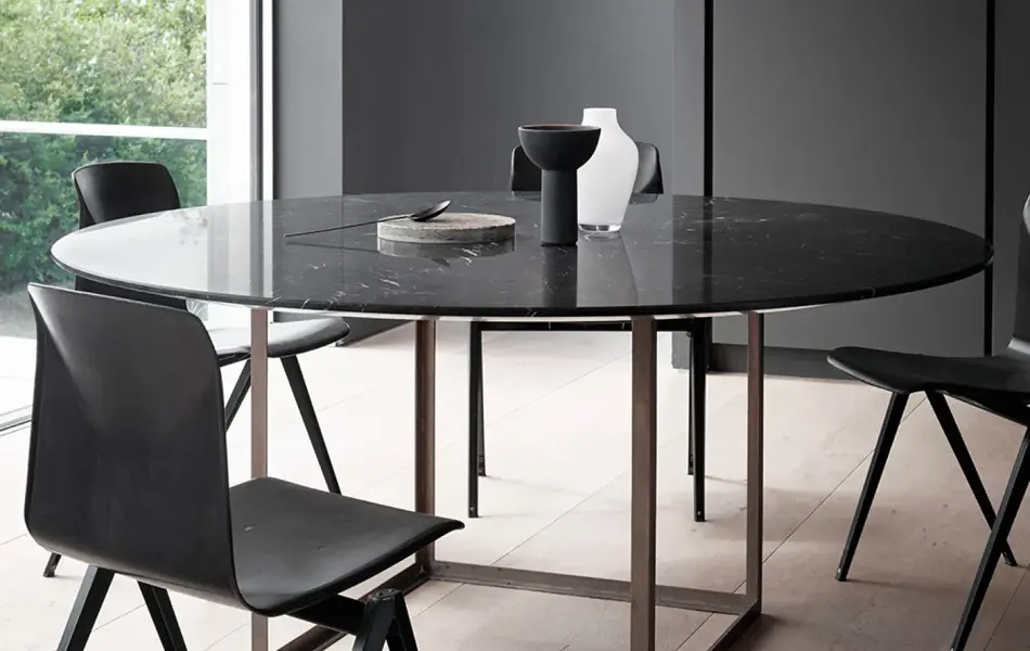 Hvit retrolampe PH5 henger over et sort spisebord.