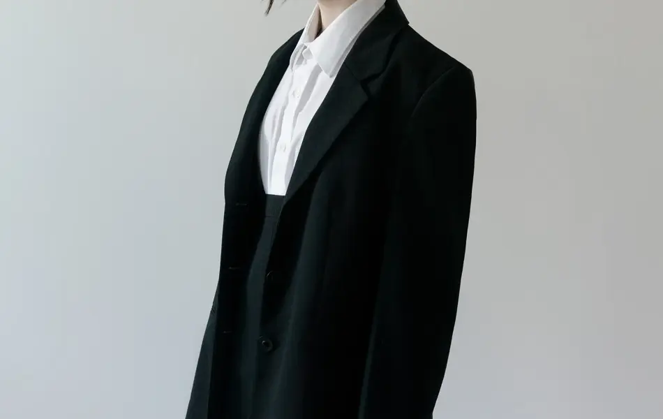 Beautiful young brunette woman wearing trendy classic black blazer White shirt and mini skirt Vintage and Korean style College or High School Student look Fashion model studio shot on light background Looking away