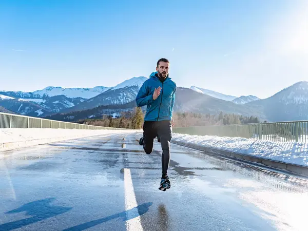 Mann som driver med løpetrening på vei, shorts over treningstightsen
