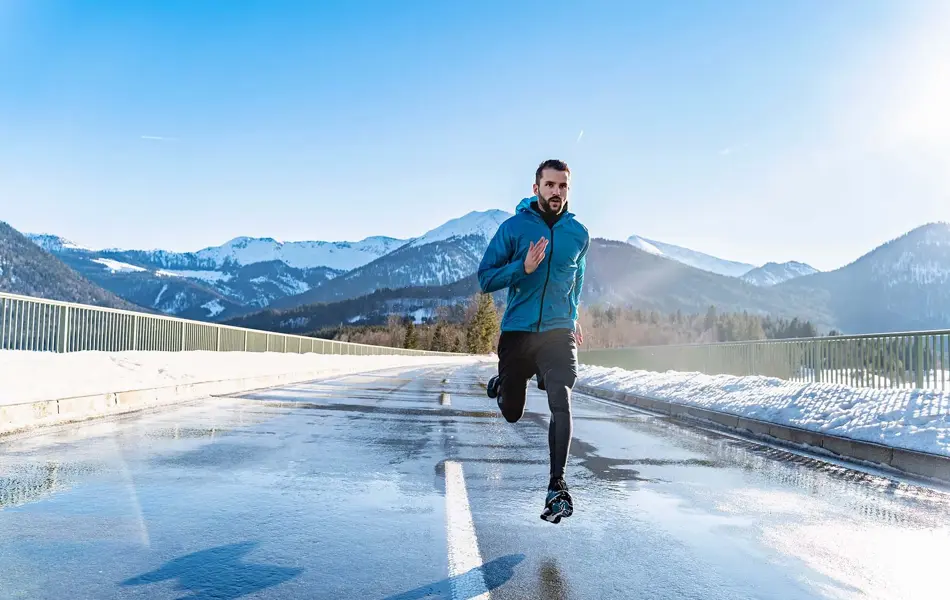 Mann som driver med løpetrening på vei, shorts over treningstightsen