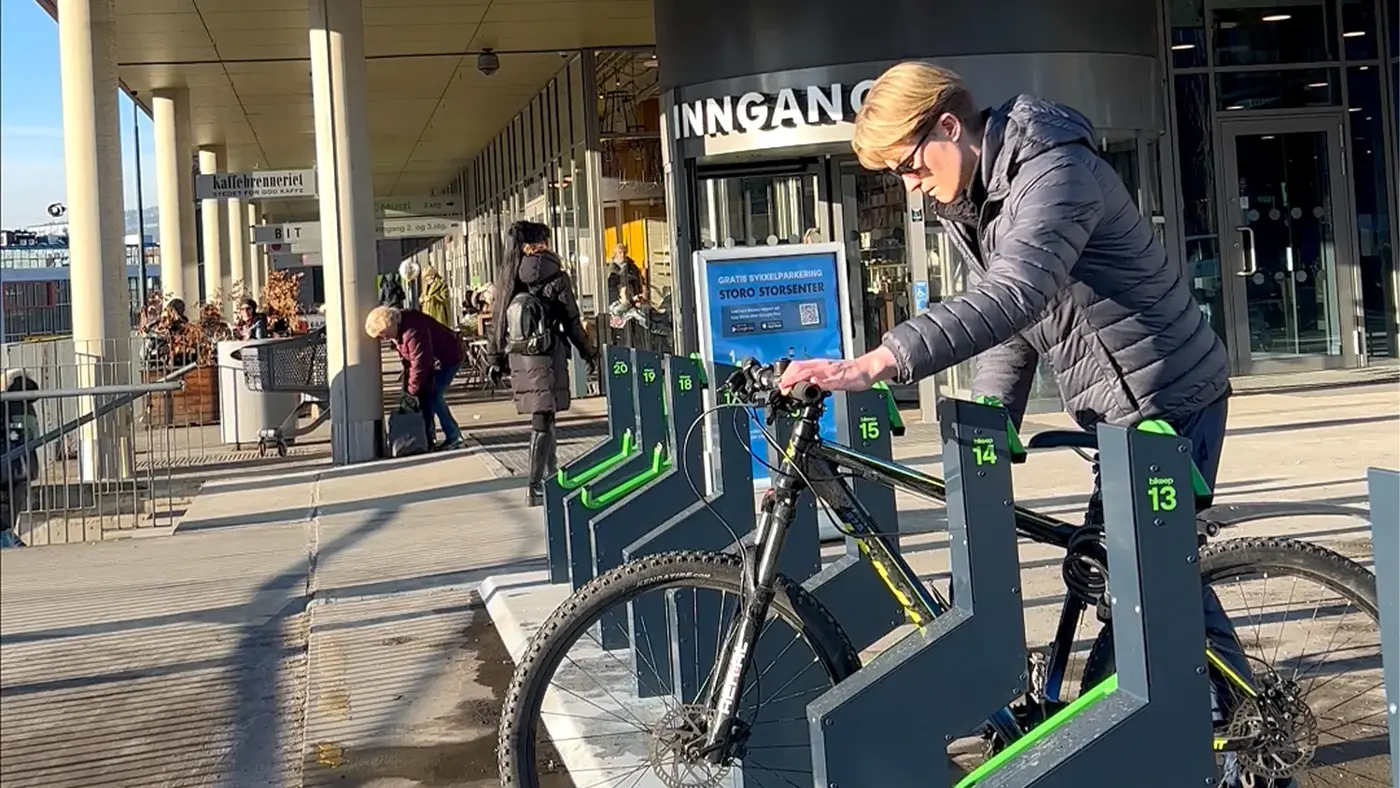 Noen som låser sin sykkel ved Storo
