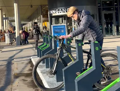 Noen som låser sin sykkel ved Storo