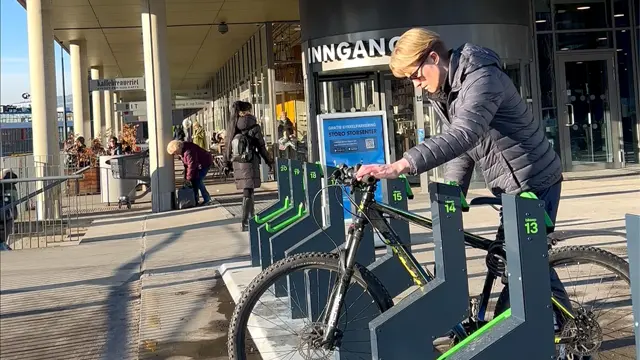 Noen som låser sin sykkel ved Storo