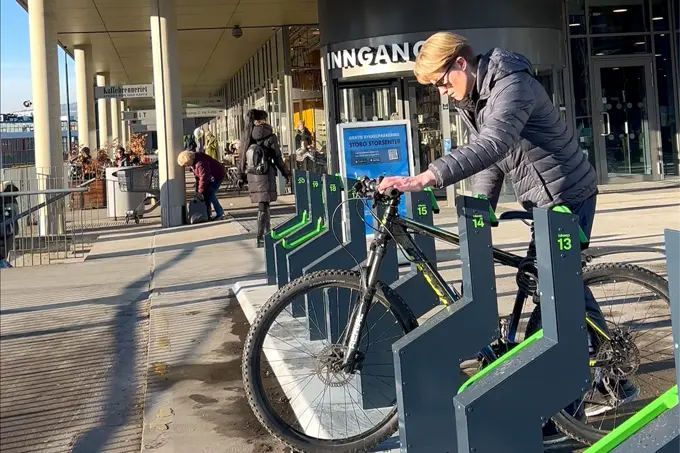 Noen som låser sin sykkel ved Storo