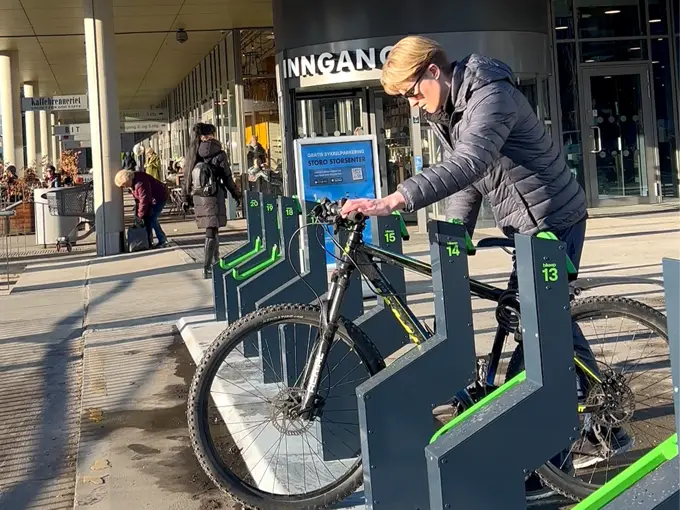 Noen som låser sin sykkel ved Storo