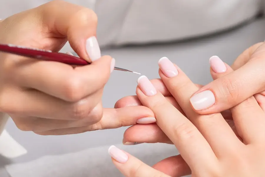 Dame får neglene fikset i en salong