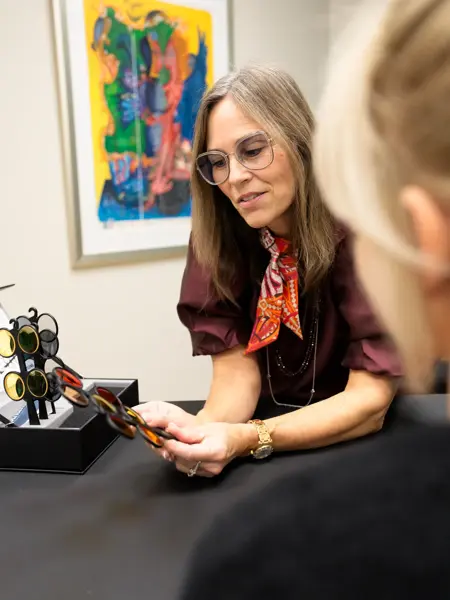 Katja Krogh sitter med en kunde og viser spesiallinser
