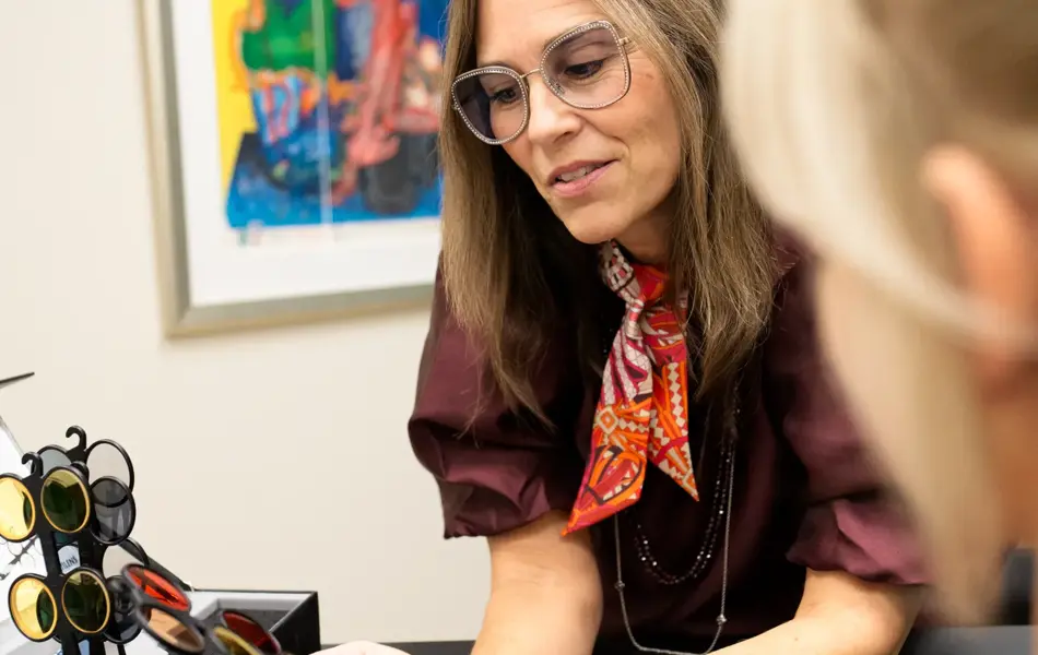 Katja Krogh sitter med en kunde og viser spesiallinser