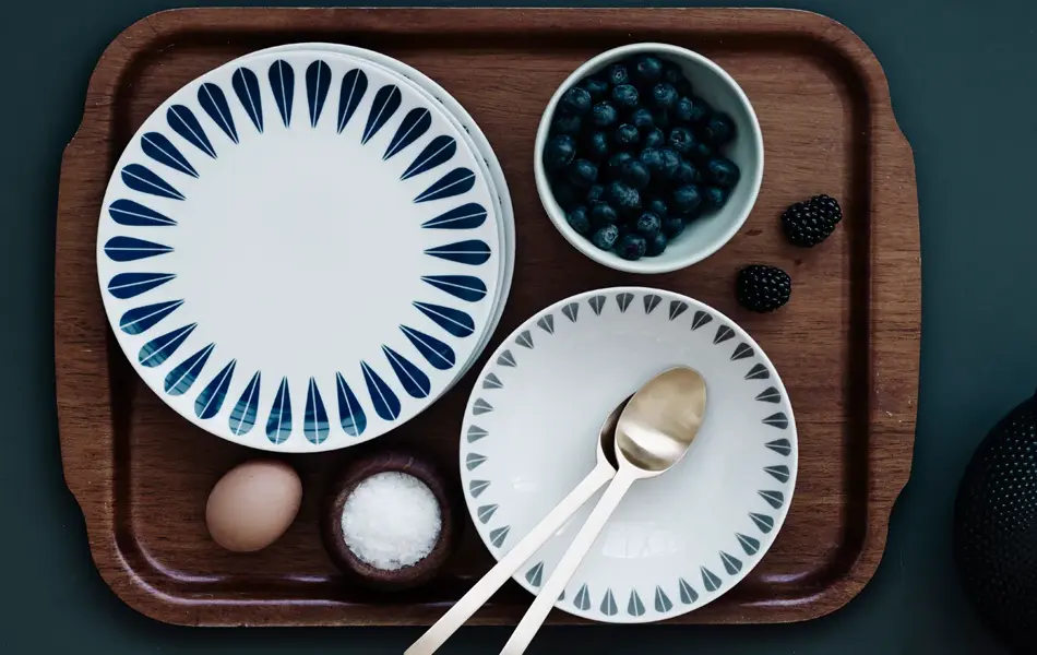Frokostfat med tallerker, blåbær, egg og salt