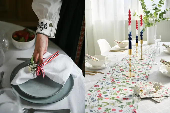 Damehånd legger en tøyserviett på grå tallerken. Bord pyntet til 17. mai.